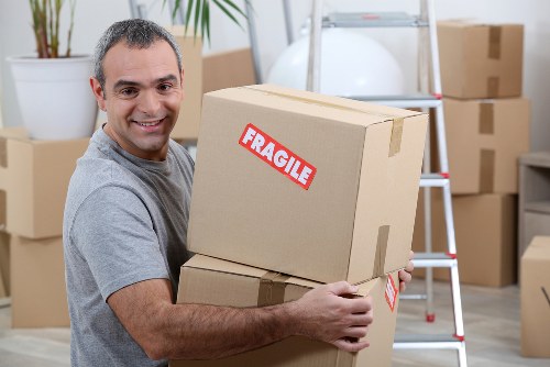 Furniture removal team handling bulky items in a Swisscottage apartment building